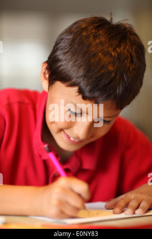 Ragazzo giovane disegno per i suoi compiti - profondità di campo Foto Stock