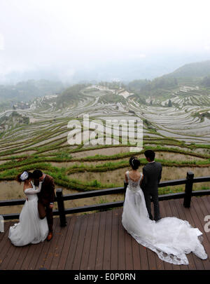 Lishui cinese della provincia dello Zhejiang. Il 17 maggio 2014. Coppie giovani posano per foto di matrimonio con i campi terrazzati come sfondo in Chongtou città della contea di Yunhe nella città di Lishui, est della Cina di Provincia dello Zhejiang, 17 maggio 2014. © Liang Zhen/Xinhua/Alamy Live News Foto Stock