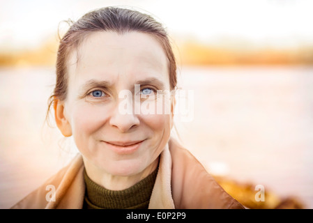 Un caldo ritratto di una bella donna senior vicino al fiume Foto Stock