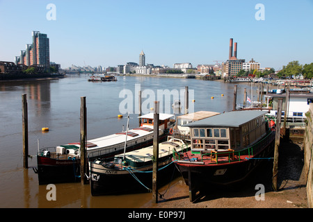 Case galleggianti ormeggiate accanto a Battersea Ponte sul Fiume Tamigi a Chelsea Foto Stock