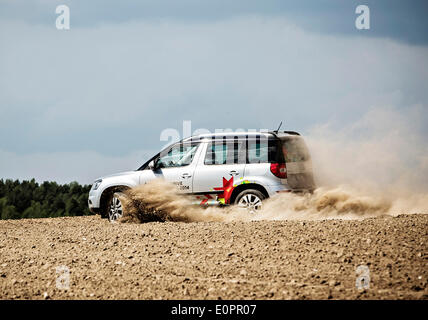Un SUV con i giornalisti scorre attraverso un campo per visualizzare una gigantesca statua di bielorusso simbolo nazionale, il Bisonte Europeo, su una autostrada che conduce a Minsk, Bielorussia, Sabato, Maggio 10th, 2014. Le autostrade in Bielorussia non conformi con West norme europee. Western Foto Stock