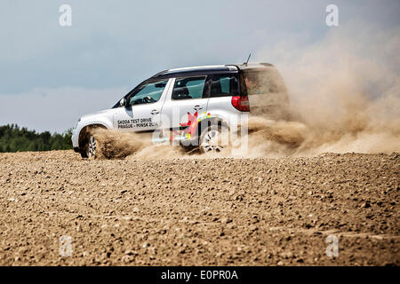 Un SUV con i giornalisti scorre attraverso un campo per visualizzare una gigantesca statua di bielorusso simbolo nazionale, il Bisonte Europeo, su una autostrada che conduce a Minsk, Bielorussia, Sabato, Maggio 10th, 2014. Le autostrade in Bielorussia non conformi con West norme europee. Western Foto Stock