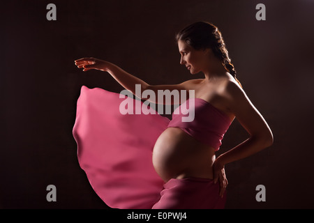Ritratto di bella donna incinta in chiffon rosa scialle Foto Stock