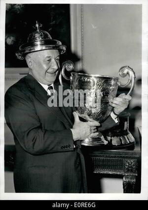 Apr. 04, 1959 - ''Tony'' vandervell è presentato con il Dewar trophy: Mr.Wilfrid Andrews, presidente del R.a.c.ha presentato oggi il Dewar Trophy per il 1958 al sig.G.a. (''Tony'') vanderell, ad un pranzo presso il Royal Automobile club, Pall Mall. Il dewar Trophy è assegnato per i più eccellenti prestazioni tecniche durante l'anno, in questo caso la vincita di costruttori 'Campionato dal sig. Vandervell il team di Vanwall racing cars. foto mostra ''Tony'' vandervell a jocular umore mette il coperchio del vaso Dewar Trophy sul suo capo dopo la presentazione di oggi. Foto Stock