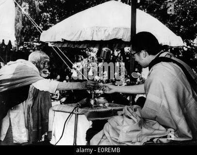 Il quattordicesimo Dalai Lama riceve un fiore da un vecchio uomo Foto Stock