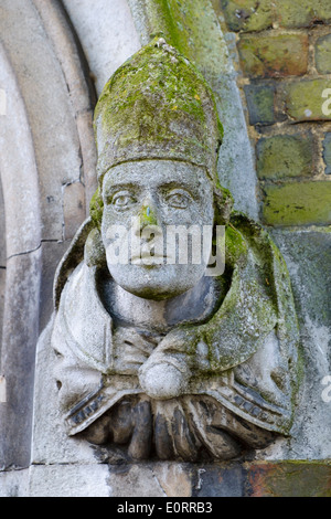 Pietra scolpita la testa di un vescovo su un edificio medievale in Winchester, England, Regno Unito Foto Stock