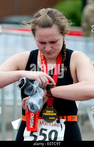 Stratford 220 Triathlon, femmina concorrente a fine gara controllo orologio Garmin Foto Stock