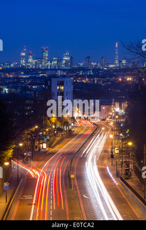 Vista dal ponte ad arco a Londra dello skyline della città e di Shard di notte con i percorsi del traffico su strada in primo piano Londra Inghilterra REGNO UNITO Foto Stock