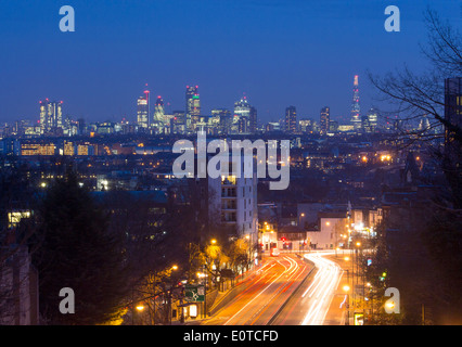 Vista dal ponte ad arco a Londra dello skyline della città e di Shard di notte con i percorsi del traffico su strada in primo piano Londra Inghilterra REGNO UNITO Foto Stock