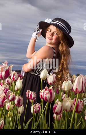 Ragazza giovane godendo di un campo di tulipani Foto Stock