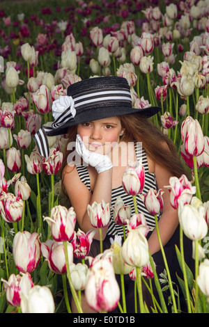 Ragazza giovane godendo di un campo di tulipani Foto Stock