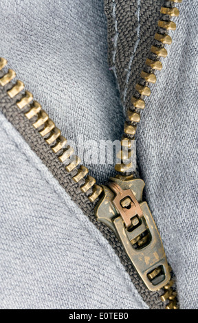 Close up zipper su un paio di jeans grigio Foto Stock