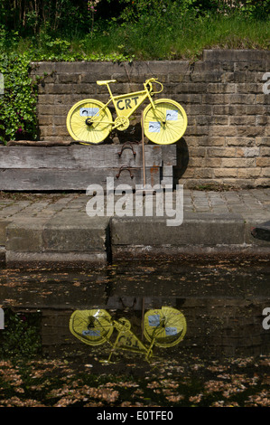 Giallo bicicletta accanto al canal in preparazione per il Tour de France, Sowerby Bridge, West Yorkshire Foto Stock