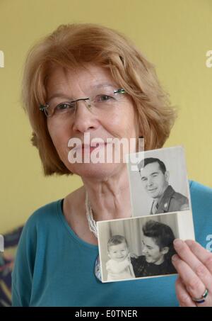 Kassel, Germania. 19 Maggio, 2014. Ilona Laudien presenta una foto di suo padre James Wilson Ramsey e uno di se stessa come un bambino e sua madre Erna Laudien a Kassel in Germania, 19 maggio 2014. Lei è una cosiddetta occupazione bambino, il suo padre era un soldato americano in Germania nel WW II. Al fine di aiutare gli altri con un destino simile, ha iniziato una selh-gruppo di assistenza per noi figli di occupazione in Kassel. Foto: UWE ZUCCHI/DPA/Alamy Live News Foto Stock