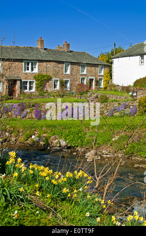 Di pietra tradizionale cottage costruito con graziosi giardini nel villaggio di Caldbeck, Cumbria, Parco Nazionale del Distretto dei Laghi England Regno Unito Foto Stock