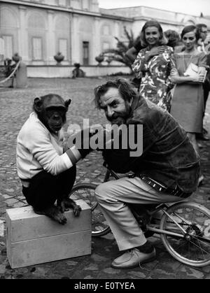 Hugh Griffith giocando con uno scimpanzé sul set Foto Stock