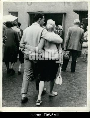 Agosto 08, 1961 - La crisi di Berlino continua. A braccetto per la libertà. Il est le autorità tedesche hanno preso misure forti per fermare il flusso di rifugiati nella zona ovest. Mostra fotografica di:- camminare insieme per la libertà - una giovane coppia - visto con alcuni dei molti altri rifugiati a Berlino Marienfelde Refugee Camp di Berlino Ovest. Foto Stock