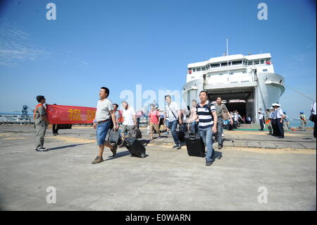 (140520) -- HAIKOU, 20 maggio 2014 (Xinhua) -- cittadini cinesi scendono dalla nave passeggeri "Wu Zhishan' dopo la nave arriva al porto Xiuying in Haikou, capitale del sud della Cina di Hainan Provincia, 20 maggio 2014. La violenza-colpito lavoratori cinesi in Vietnam sono arrivati al porto di Haikou martedì. Il governo cinese ha inviato quattro navi di domenica per evacuare riot-colpito lavoratori cinesi in Vietnam dove gravi atti di violenza di targeting le società straniere dal maggio 13 ha lasciato due cittadini cinesi morti e più di 100 altri feriti. (Xinhua/Xia Yifang) (mp) Foto Stock