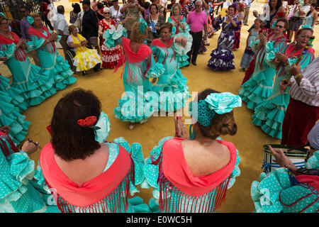 Le donne indossano abiti di zingaro eseguire andalusi tradizionali danze a la feria del Caballo, Jerez de la Frontera Foto Stock