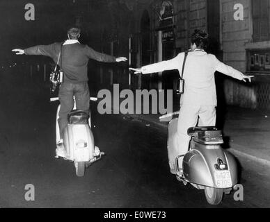 Roman paparazzi in competizione per vedere chi è in grado di stare sulla Vespa più lunga Foto Stock