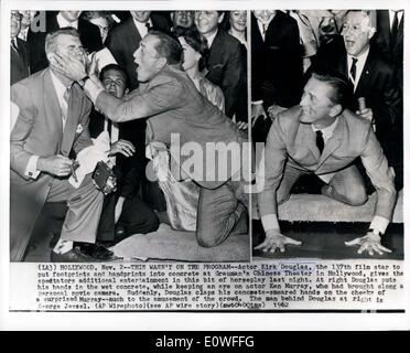 Nov. 02, 1962 - questo non era sul programma; attore Kirk Douglas, il 137il film di star per mettere di footprint e handprints in tondi per cemento a Grauman's Chinese theater in Holly Wood, dà gli spettatori intrattenimento aggiuntivi in questo bit di stolto la scorsa notte. A destra Douglas mette le mani nel calcestruzzo bagnato, mantenendo un occhio su attore Ken Murray, che aveva portato lungo un filmato personale fotocamera. Improvvisamente, Douglas tubicini il suo concreto cosparse le mani sui controlli di una sorpresa molto di Murray per il divertimento della folla. L'uomo dietro Douglas a destra è George Jessel. Foto Stock