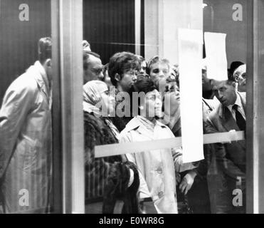 Scioccato americani si radunano in ambasciata per leggere le news Foto Stock