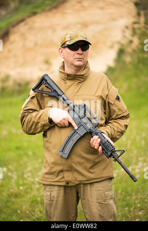 Soldato vestito in un camuffamento con una pistola nel outdoor Foto Stock