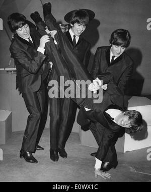 I Beatles di membri che detengono Ringo Starr capovolto Foto Stock