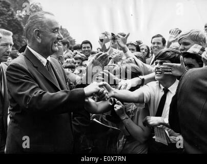 Il presidente Johnson scuote le mani con gli studenti Foto Stock