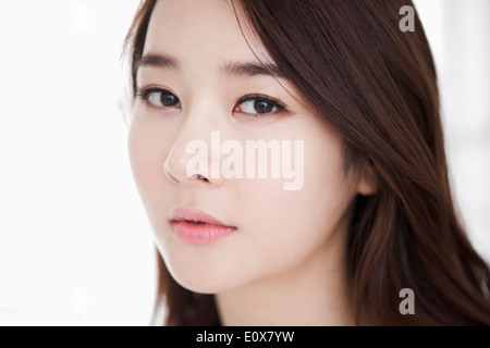 Una donna con un serbatoio bianco top in posa Foto Stock