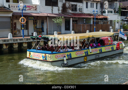 Imbarcazione turistica prendendo i turisti sulle rive di un fiume viaggio nella vecchia città malese di Malacca Foto Stock