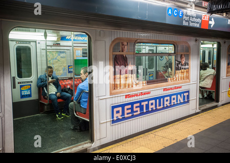 Una linea di lavaggio treno della metropolitana a Times Square è avvolto nella pubblicità promuovendo il nuovo tempo di repliche del Seinfeld televis Foto Stock