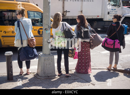 Le donne di attendere in corrispondenza di una intersezione sulla Delancey Street nel quartiere di Lower East Side di New York Foto Stock