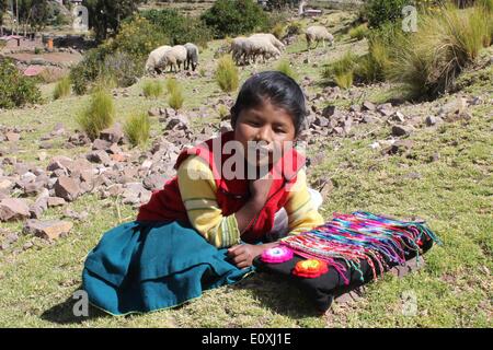 Puno, Perù. 13 Maggio, 2014. Una giovane ragazza vende bracciali su Taquile isola galleggiante sul lago Titicaca, nella regione di Puno, Perù, 13 maggio 2014. Il lago Titicaca e le sue isole galleggianti in Perù Puno regione hanno non solo le attrazioni naturali ma anche di cultura unica causa del quechua persone da Juliaca vivono lì. Il lago Titicaca si trova a Collao altopiano, con le isole di Luna, Taquile, Amantani, Uros e Suriqui in esso. © Luis Camacho/Xinhua/Alamy Live News Foto Stock