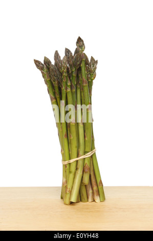 Mazzetto di asparagi su una tavola di legno contro uno sfondo bianco Foto Stock