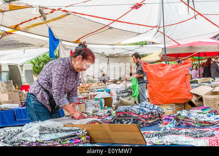 Il settimanale Martedì mercato di Foca, Distretto di Izmir, Turchia, titolare di stallo di disporre di tessuti. Foto Stock