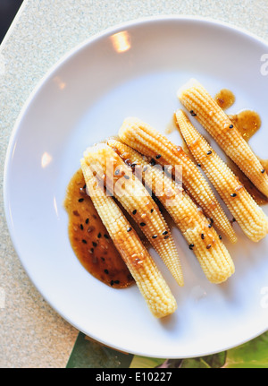 Baby Insalata di mais wite salsa di sesamo sul piatto bianco Foto Stock