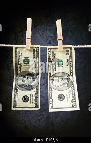 Moneta americana. USA il denaro, le fatture del dollaro appeso sulla corda fissata con perni di vestiti. Foto Stock