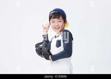 Un giovane ragazzo che posano con un guanto da baseball e una palla Foto Stock