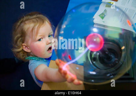 Visitatore - invecchiato 2 anni - gode di giocare con una palla al plasma sul display durante una rara Open Day presso il National Physical Laboratory di Teddington, Londra, Regno Unito. Foto Stock