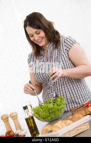 Apr. 22, 2010 - 22 Aprile 2010 - Cook - Taglie donna felice la preparazione di insalata di verdure con lattuga in cucina moderna Foto Stock