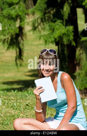 Lug. 12, 2010 - Luglio 12, 2010 - Felice giovane donna con libro nel parco sulla giornata di sole Â© CTK/ZUMAPR) Foto Stock