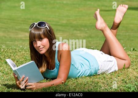 Lug. 12, 2010 - Luglio 12, 2010 - sorridente giovane donna sdraiati sull'erba con libro in estate park Â© CTK/ZUMAPRE Foto Stock