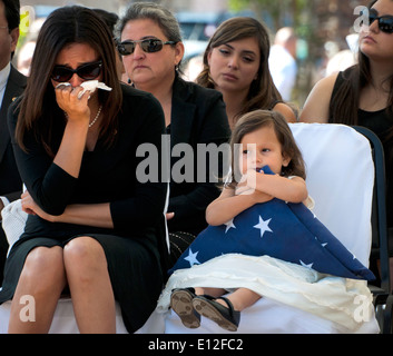 Vicki Baker, sinistra, vedova di U.S. Army Sgt. 1. Classe Jeffrey Baker, piange mentre la loro figlia detiene una bandiera statunitense durante il quarantacinquesimo annuale di l'eliminazione degli ordigni esplosivi Memorial Wall cerimonia Maggio 3, 2014 a Eglin Air Force Base in Florida. Otto nomi di Marines e soldati sono stati aggiunti, portando il totale a 306. Foto Stock