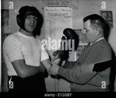 Dic. 26, 2011 - Charles Humez ha i suoi guantoni da pugilato legato dal suo manager, M. Sion, prima di un allenamento bout. Humez di Francia si prepara a incontrare il Turpin: Charles Humaz della Francia è ora in una rigorosa formazione per il suo mondo middleweight championship lotta con British middleweight champion, Randolph Turpin, che si svolge presso la città bianca su giugno 9th. Charles Humez vive a Henin Lietard, vicino a Douai, delle miniere di carbone e di distretto Humez stesso era un ex minatore. Turpin ha vinto la sua ultima lotta quando il suo avversario, Walter Cartier di New York è stato squalificato per l'azienda. Foto Stock