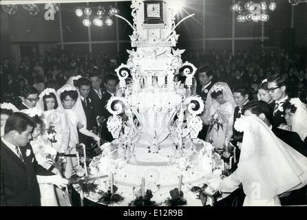 Febbraio 24, 2012 - Matrimonio ALLA VIGILIA DI CAPODANNO. La cerimonia di nozze per 16 coppie di sposa e lo Sposo era avvenuta alla vigilia di Capodanno all'hotel Takanawa, Tokyo. Come il colpo di clock la mezzanotte, presero un giuramento per il loro futuro. La foto mostra: sedici coppie di sposa e lo sposo il taglio l'orologio a forma di torta di nozze alla cerimonia per la Vigilia di Capodanno, Tokyo. Foto Stock