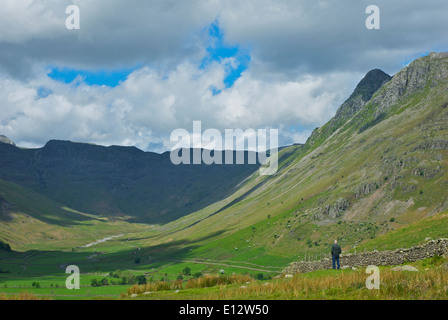 Uomo che guarda verso il basso sopra la valle di Mickleden, grande Langdale, Parco Nazionale del Distretto dei Laghi, Cumbria, England Regno Unito Foto Stock