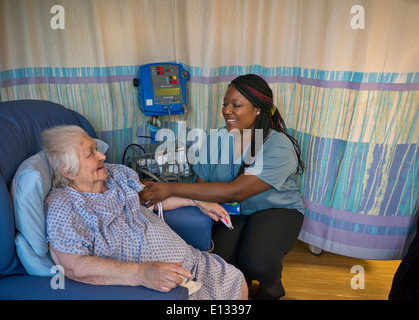 Infermiera ospedaliera e anziana signora nel reparto ospedaliero che la ha Pressione del sangue presa attraente sorridente infermiera ospedale Foto Stock