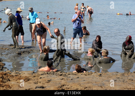 La gente la balneazione nel fango del Mar Morto, Israele Foto Stock