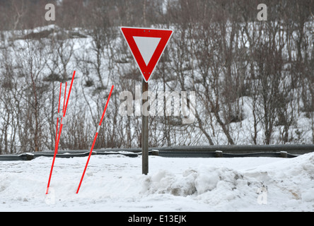 Cartello stradale e poli potenziale indica la profondità della neve, Lofoten, Norvegia Foto Stock